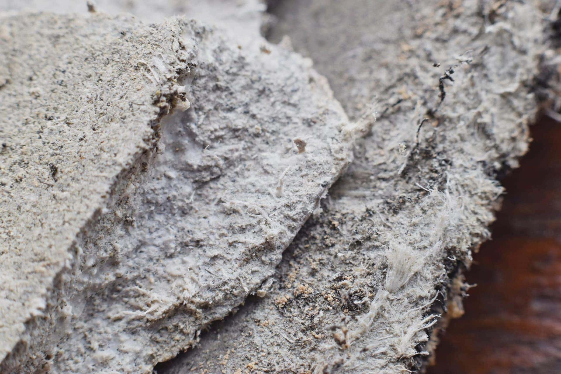 Close up of broken asbestos cement showing exposed fibres